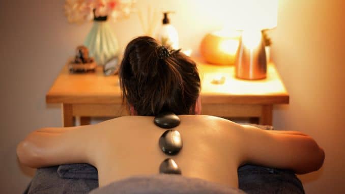 image representing a women with hot stone massage therapy